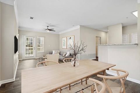 a living room and dining room with a wooden table